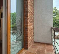 A balcony with a brick wall and glass doors in a five or more room apartment.