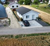 A family house in Nižná next to a large hall, with a parking lot and an access road.