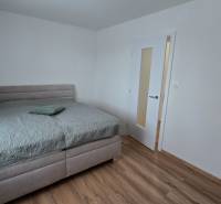 Bedroom in a family house with a bed and wooden floor.