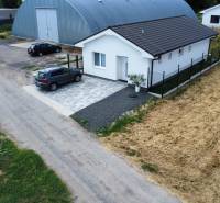 A family house in Nižná with an asphalt road and a parked car.