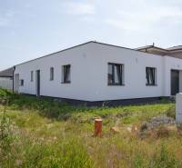 A family house in Zohor with a white facade and a garden on a sunny plot.