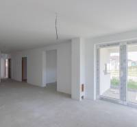 The interior of a family house with an unfinished floor and large windows.