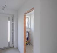 The interior of a family house with white walls, lighting, and an uncovered construction opening.
