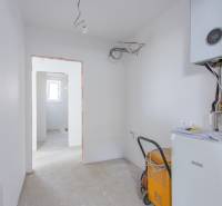 Technical room in a family house with heating equipment and visible cables.