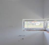 Unbuilt kitchen in a family house with drawers and a window.