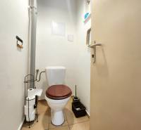 Bathroom in a 2-room apartment, with a toilet and a toilet paper holder.