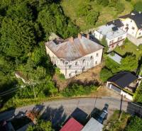 Aerial view of a building surrounded by greenery and neighboring houses in the village of Hodruša-Hámre.