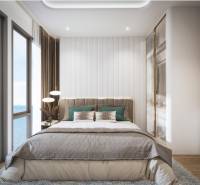 A bright bedroom with a large window and a sea view in a three-room apartment.