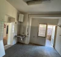 Interior of commercial premises with a sink, tiles, and glass doors.