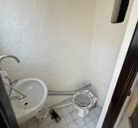 A small interior with a sink and white tiles in commercial premises.