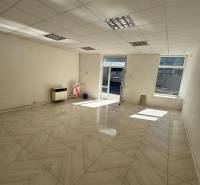 Commercial premises with large windows and tiled floors, spacious and bright.