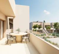 A balcony with a table and chairs in a 4-room apartment overlooking greenery and a pool.