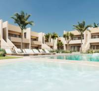Pool and loungers in the complex of 4-bedroom apartments in the town of Roda with palm trees.