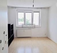 A studio apartment with white walls and windows matches the furniture and flooring.