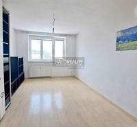 Spacious studio with white walls, wooden floor, and a large window.