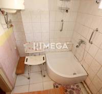A bathroom in a family house with tiled walls and a shower tray.