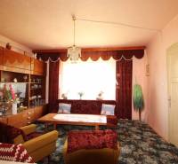 Living room with retro furniture, carpets, and curtains in a family house.