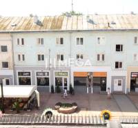 Liberators' Square Street in Michalovce with shops and a shelter.
