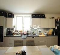 A kitchen in a 3-room apartment with light furniture and a dining table.