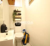 Bathroom in a 3-room apartment with a toilet, sink, and wall shelf.