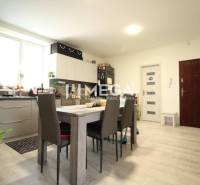 A kitchen with a dining table and six chairs in a 3-room apartment.