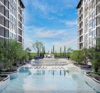 The construction of apartments in Pattaya includes a pool and gardens between the buildings.
