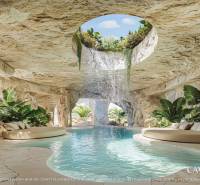 The interior space with a pool resembles a cave, with a waterfall and plants around.