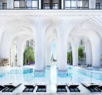 Luxury apartment development with a pool and white columns reminiscent of futuristic architecture.