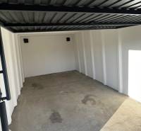 Empty garage with a concrete floor and a metal ceiling.