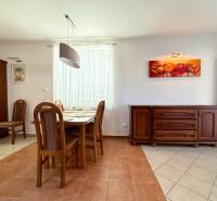 Dining area of a family house with wooden furniture and paintings.