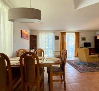 Dining room and living room in a family house with wooden furniture and a large carpet.