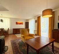 A living room in a family house with a comfortable armchair, a television, and a dining table.