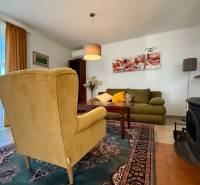 Living room in a family house with an armchair, sofa, fireplace, and a painting on the wall.