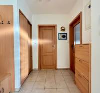 A hallway in a family house with wooden furniture and tiled flooring.