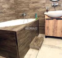 A bathroom in a family house with a built-in bathtub and a wooden sink.