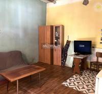 Living room with a sofa, wardrobe, and television in a family house, simple furnishings.