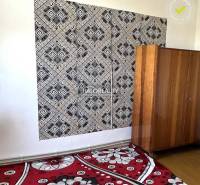 Black and white geometric wallpaper, wooden cabinet, and floral carpet in a family house.