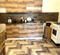 A kitchen in a family house with wooden cabinets, a stove, and a refrigerator.
