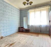 A room with a wooden floor, blue wallpaper, and vintage furniture on the Property - living.