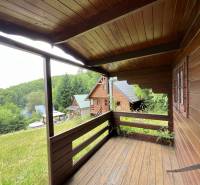 A wooden porch of a family house in Štefultov with a view of the wooded surroundings.