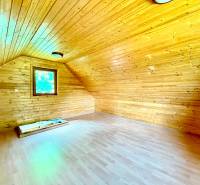 Wooden interior cladding of the attic with a window in a family house.