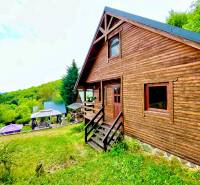 A wooden family house in Štefultov surrounded by forests, with a garden gazebo.