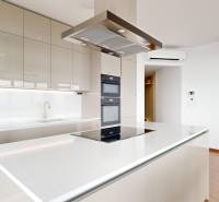 Spacious kitchen with a cooktop in a 4-room apartment with glass doors.