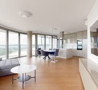 Bright living room in a 4-room apartment with large windows and a modern kitchen.