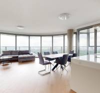 Living room with a round view, sofa, dining table, and glass walls in a 4-room apartment.