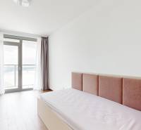 A bright room with a bed, white walls, and a window in a 4-room apartment.