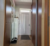 Entrance hallway in a family house with a tiled floor and a built-in wardrobe.