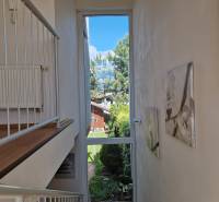 Interior of a family house with a large window, garden view, and staircase.