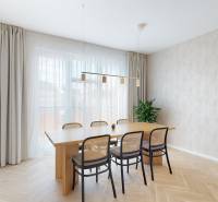 A dining table with six chairs and a plant in a 3-room apartment.