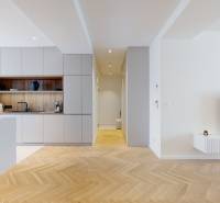 Spacious kitchen corner and living room in a 3-room apartment with wooden flooring and modern equipment.
